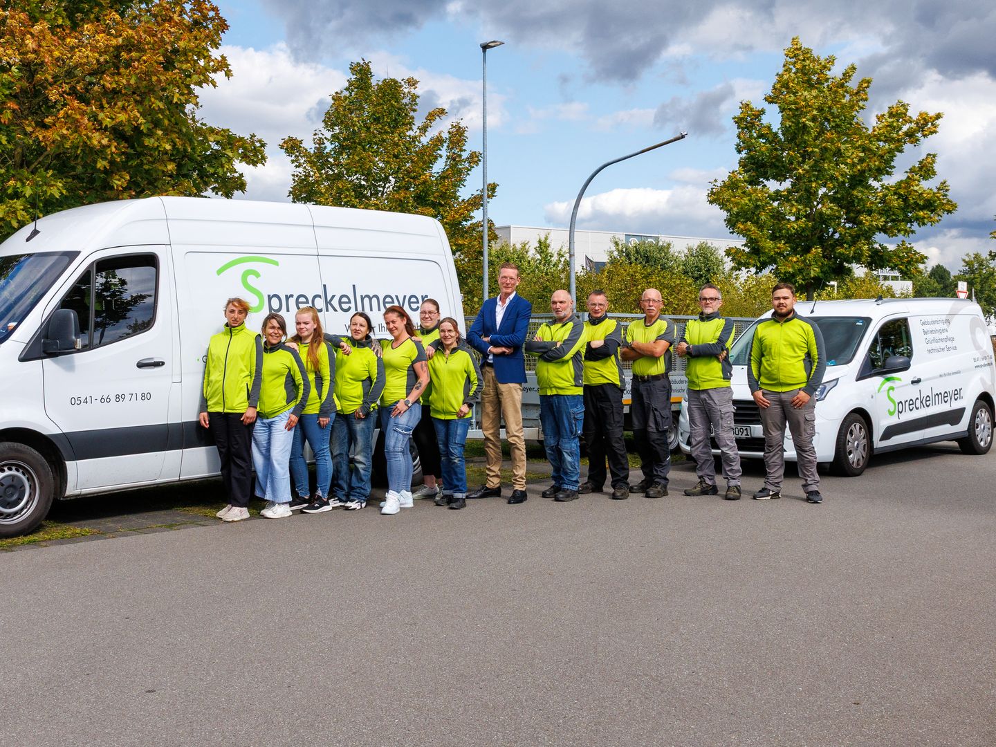 Das Team von Spreckelmeyer facility service vor den Firmenfahrzeugen